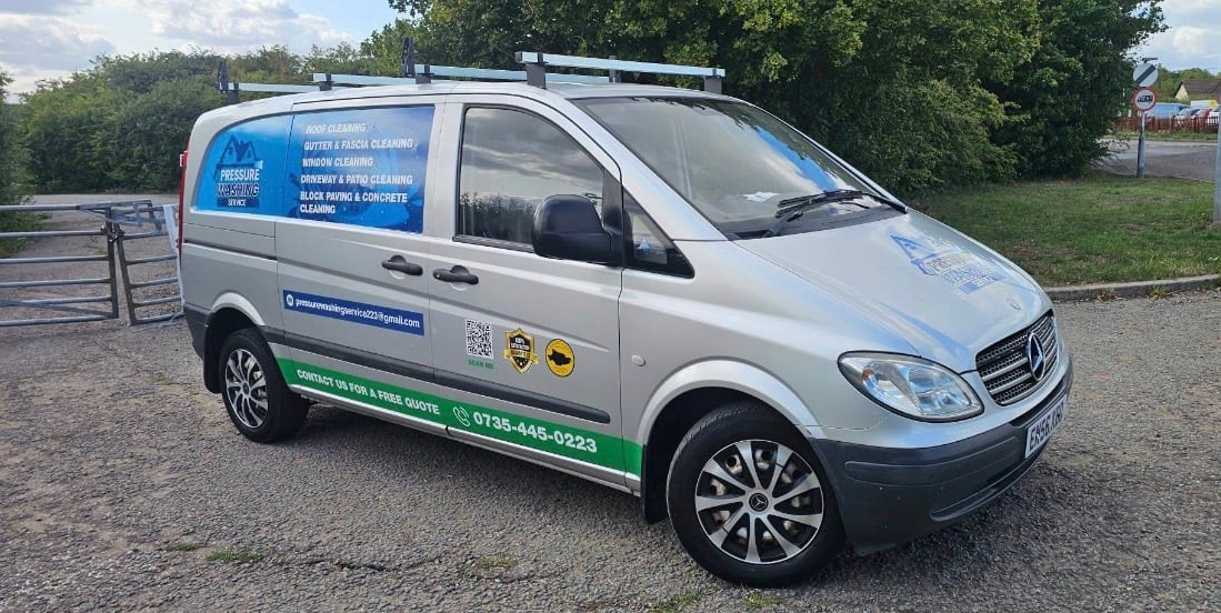 White service van with blue branding parked on gravel