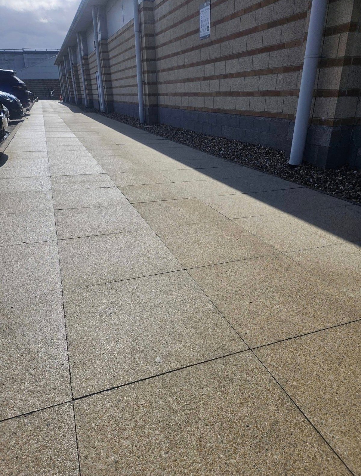 Clean paved outdoor pathway along modern building after professional pressure washing
