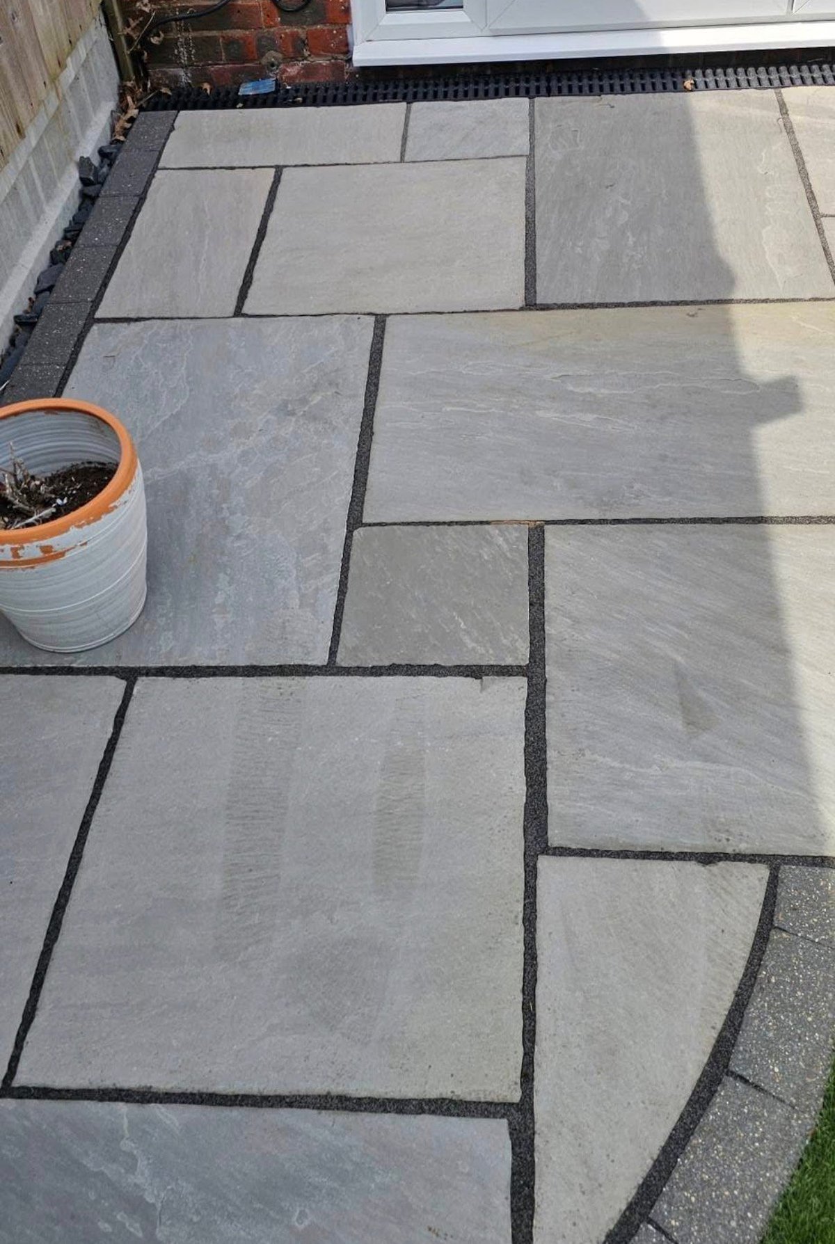 Patio with gray concrete pavers in herringbone pattern after professional restoration